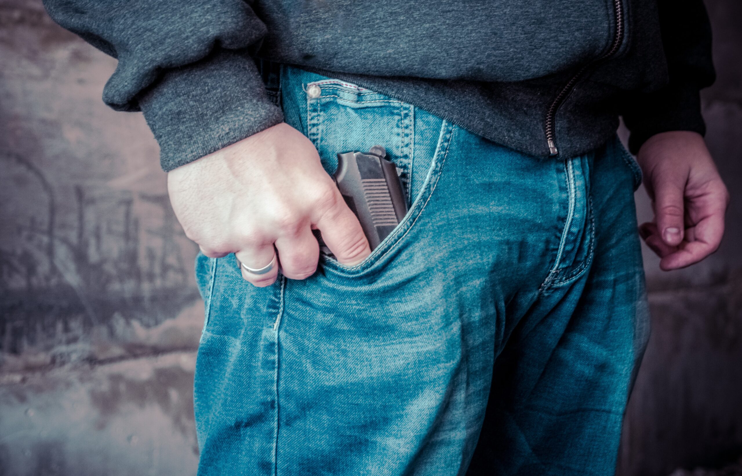man holding gun in pocket